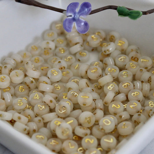 Gold numbers on cream beads